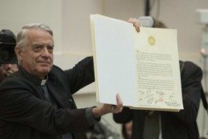 Lombardi shows a book signed by Pope Francis during a meeting with religious leaders at the Pontifical Academy of Sciences at the Vatican
